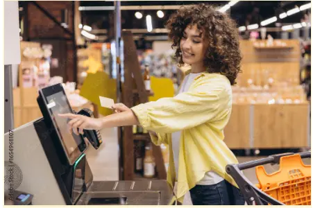 mulher em guichê de autoatendimento em mercado para ilustrar texto sobre experiência de compra no varejo